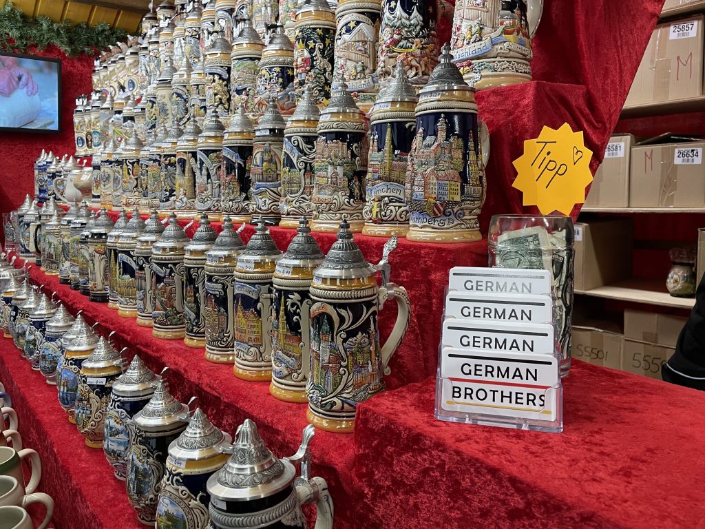 traditional made in germany beer steins displayed on a shelf on red fabric